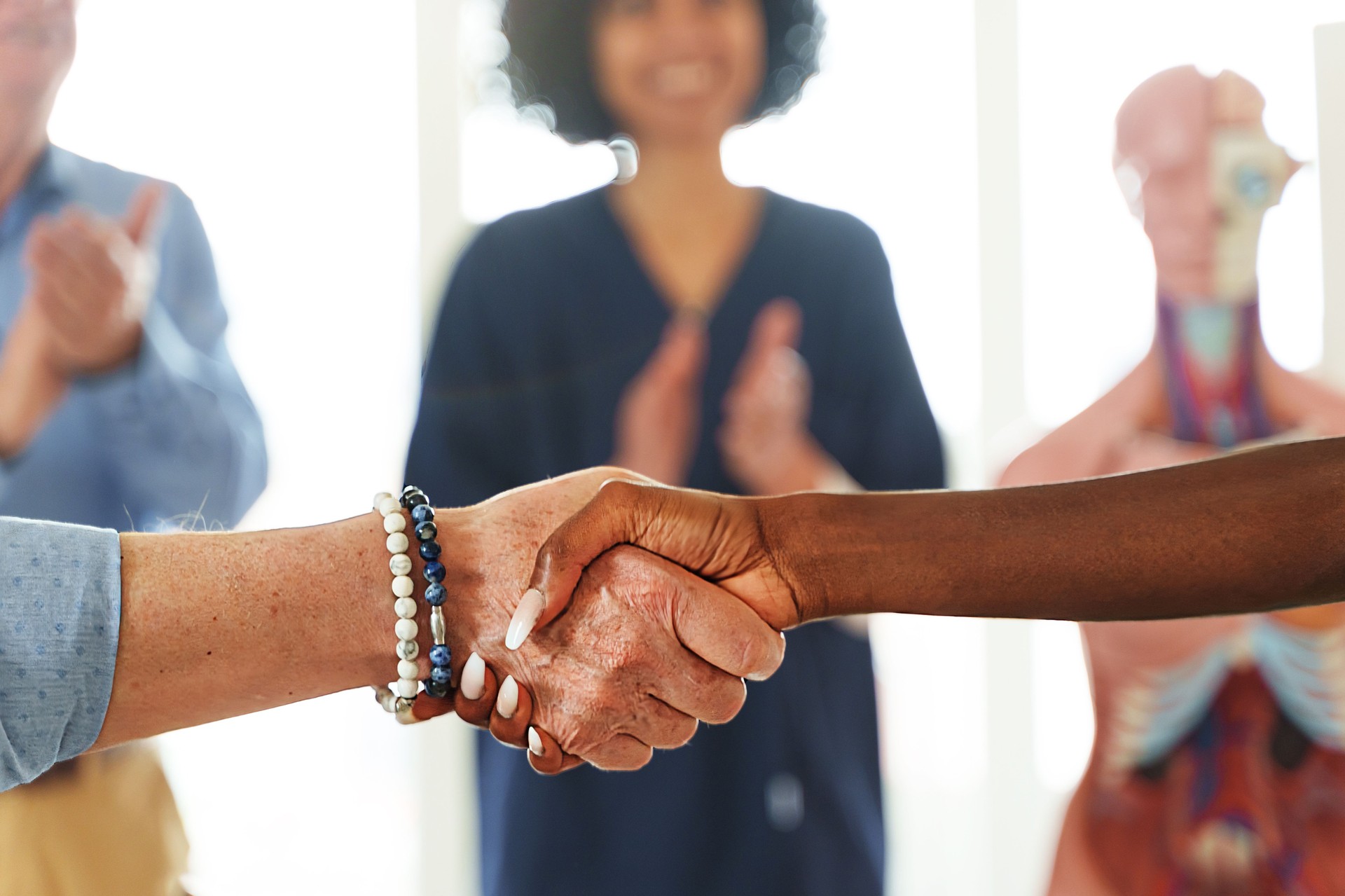 Handshake Between Senior and Young African Woman in Medical Setting